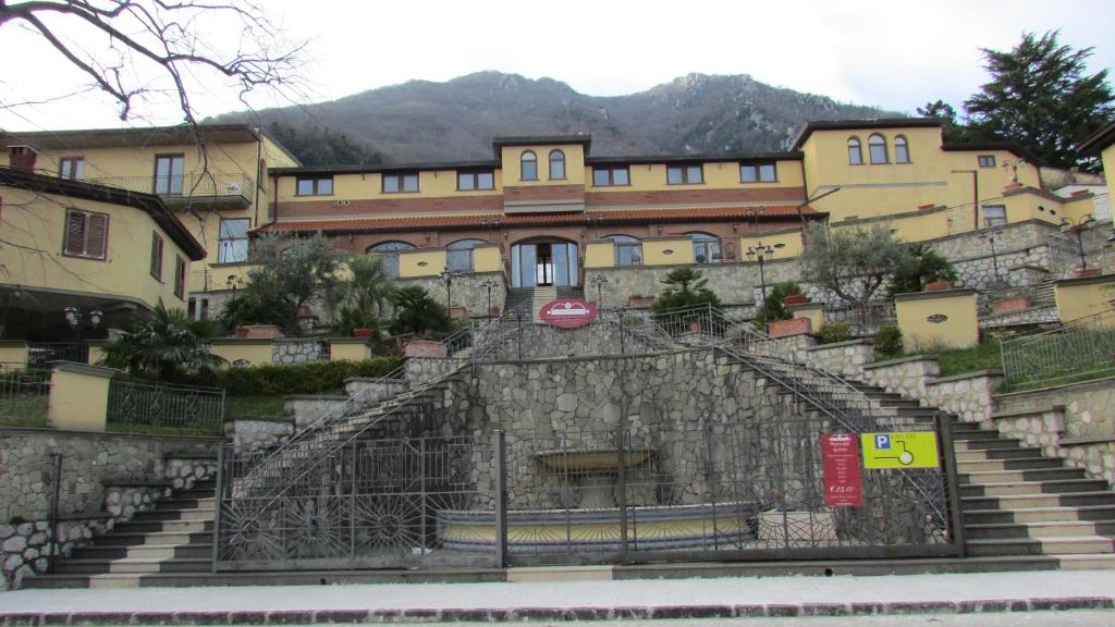 a building with a fence and a sign on the side of it at Hotel Al Palazzetto Set Fair in Ospedaletto dʼAlpinolo