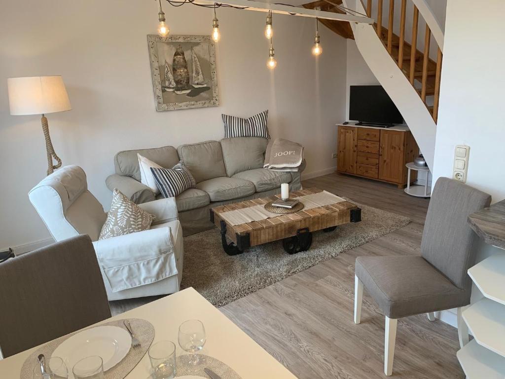 una sala de estar con un sofá y una mesa en FeWo Woge, en Grödersby