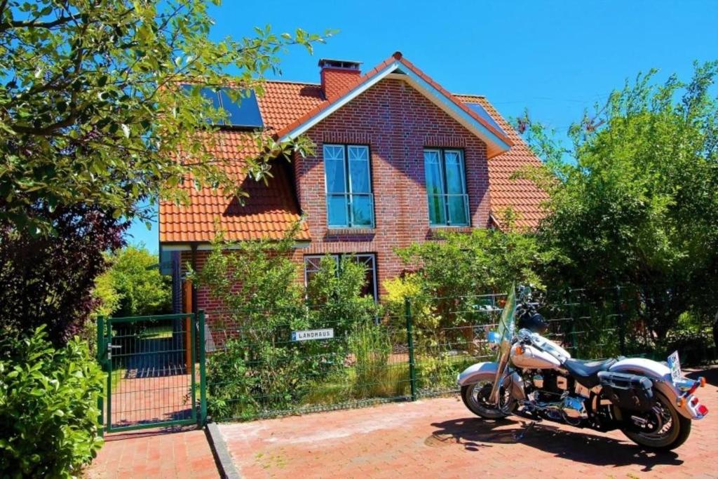 una motocicleta estacionada frente a una casa en Landhaus, en Kellenhusen