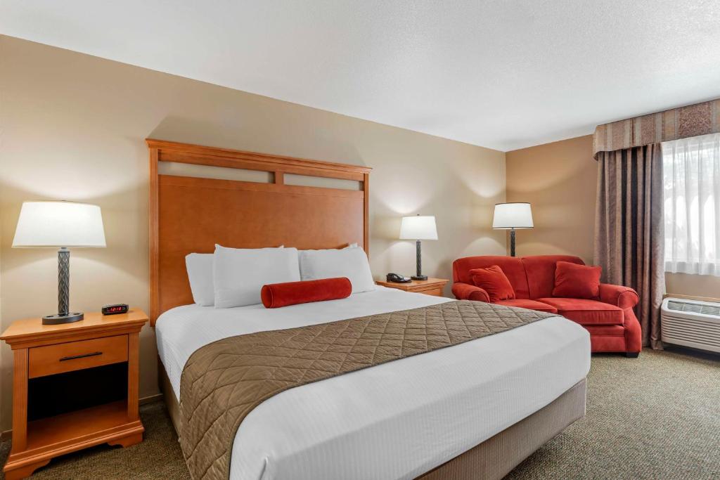 a hotel room with a bed and a red chair at Best Western Rory & Ryan Inns in Burns