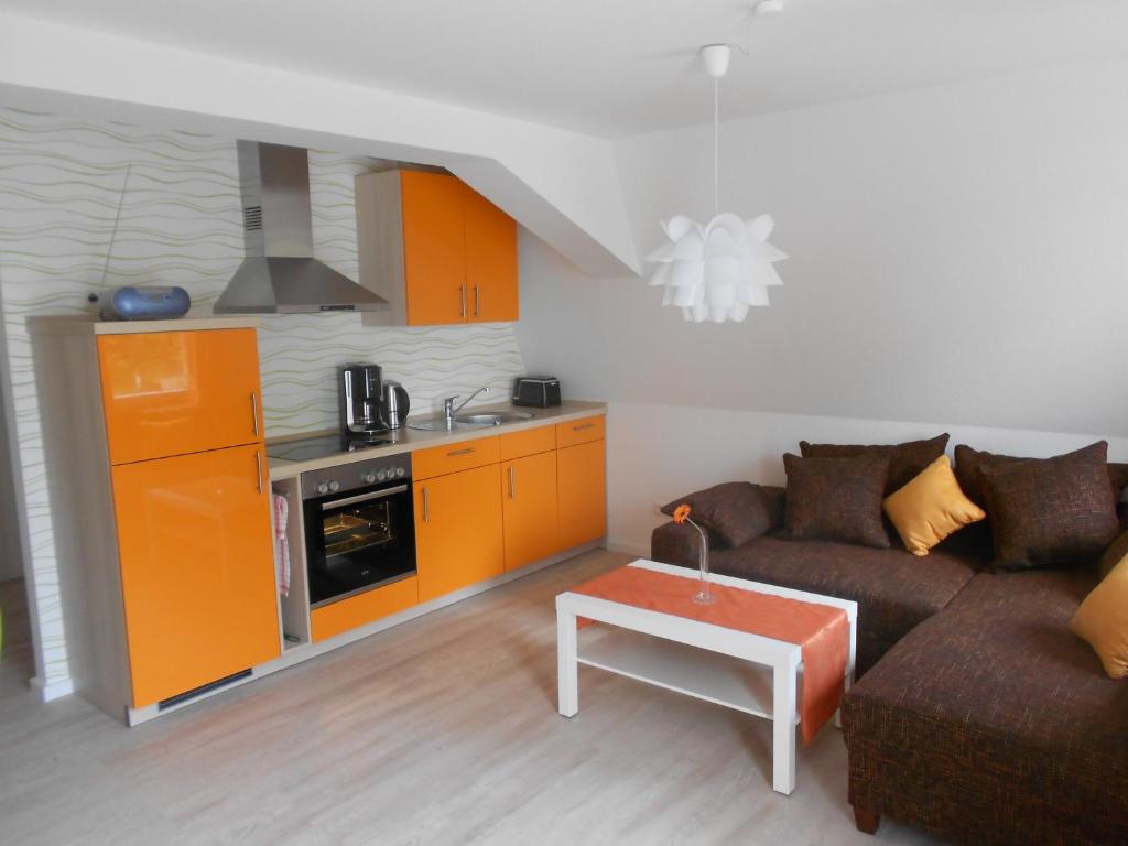 a living room with a couch and a kitchen at Ferienwohnung Haus Glückauf in Kölpinsee