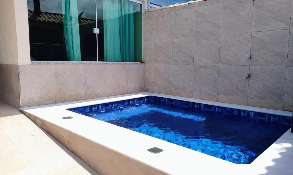 a swimming pool in a bathroom with a shower at Casa Balneário Arpoador in Peruíbe