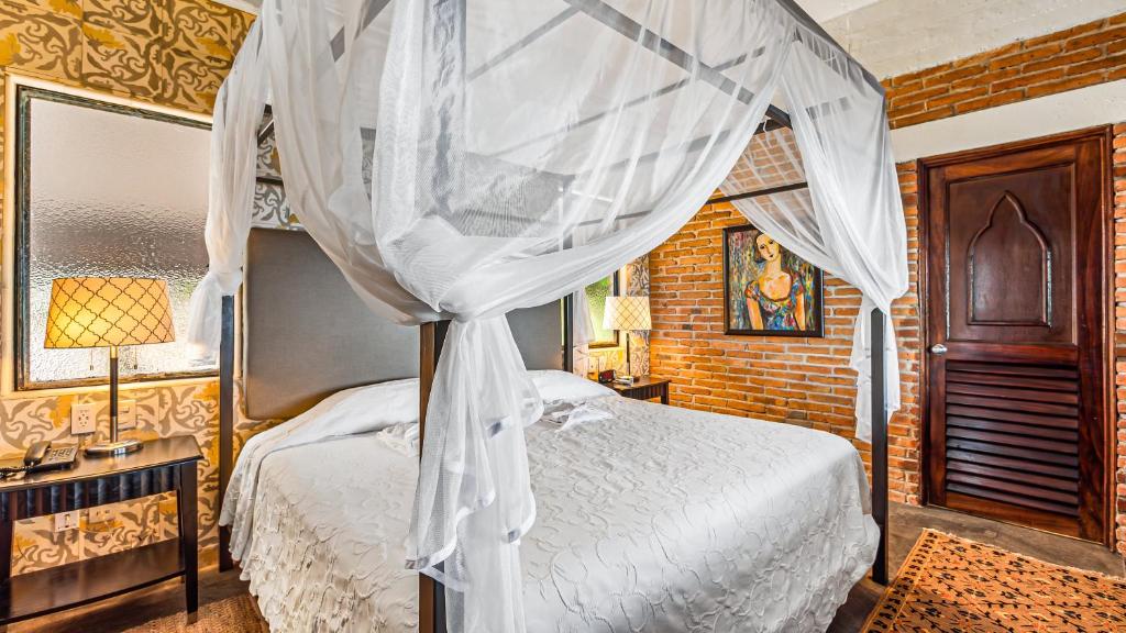a bedroom with a bed with a canopy at Quinta Maria Cortez Beach Hotel in Puerto Vallarta