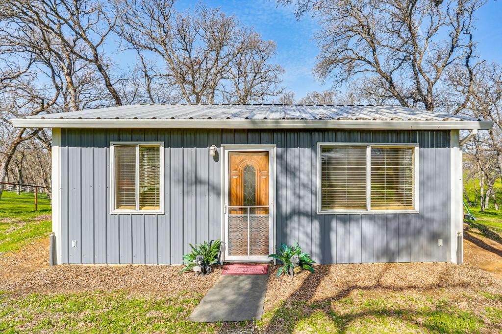 a gray shed with a door in a yard at Fish, Hike & Relax: Rural Red Bluff Cottage in Red Bluff