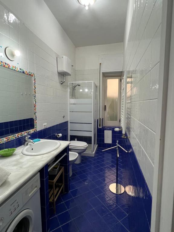 een badkamer met 2 wastafels, een toilet en een douche bij La Casa Lungo Il Mare in Maiori