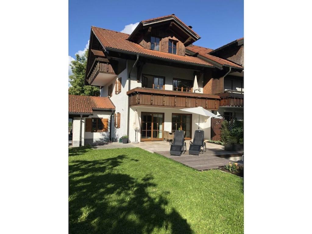 ein großes Haus mit grünem Rasen davor in der Unterkunft Bergwiese Comfortable holiday residence in Oberstaufen