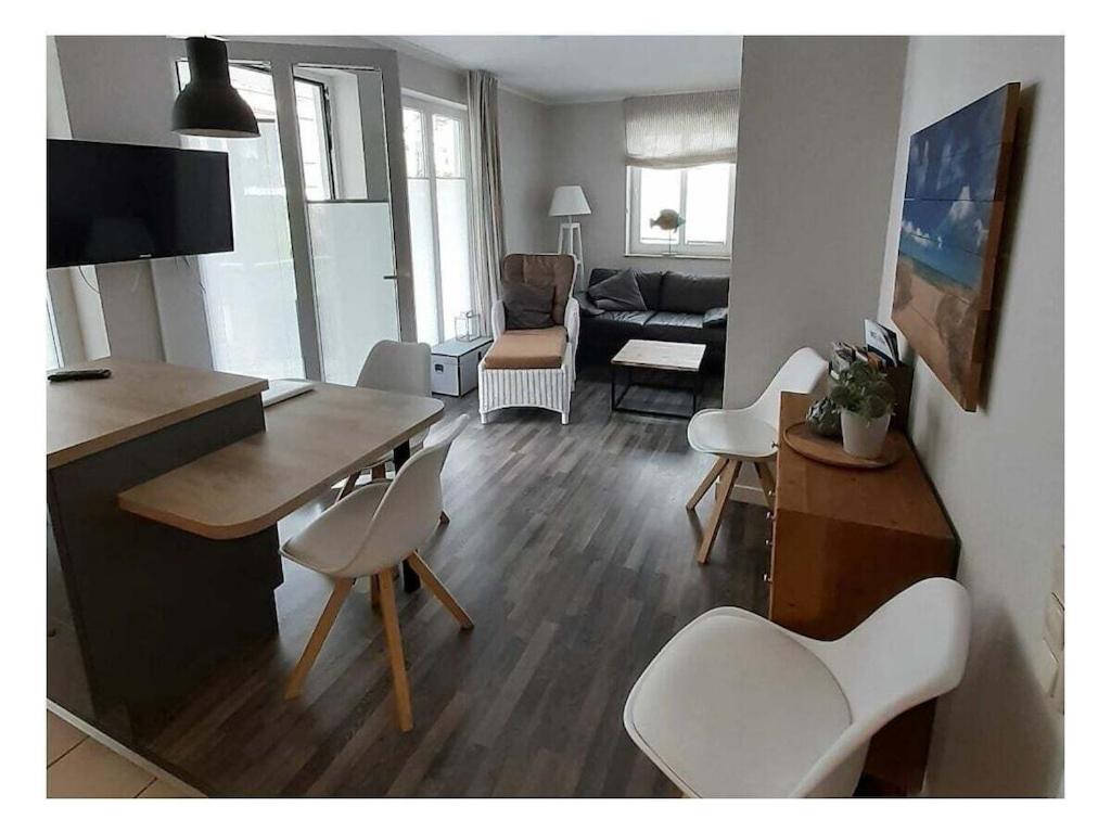 a living room with a table and white chairs at Koehler 2 Buskam 23 in Göhren