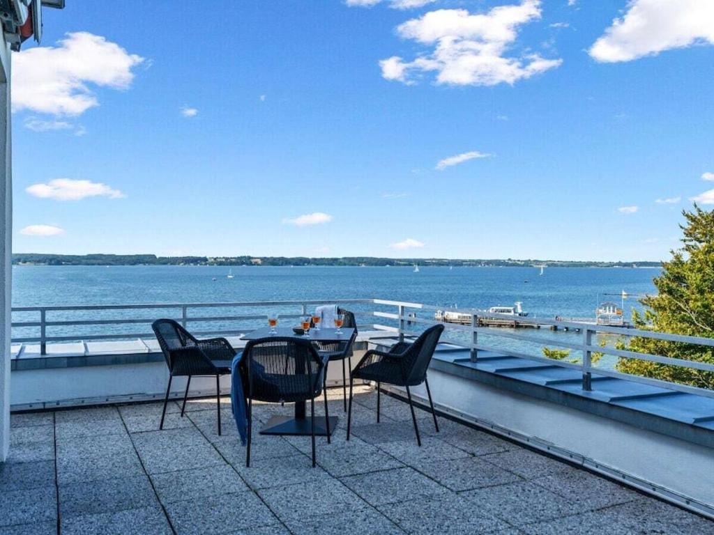 UlstrupfeldにあるBeach Terrace 11 Comfortable holiday residenceのテーブルと椅子、水辺の景色を望むバルコニー