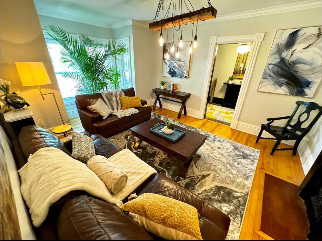 a living room with a leather couch and a table at Historic Charlottetown Twin Towers in Charlottetown