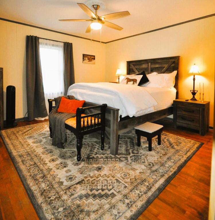 a bedroom with a bed and a chair and a fan at Country Feel with Downtown Convenience - WiFi - 10 Min to Red River Gorge & Natural Bridge in Stanton