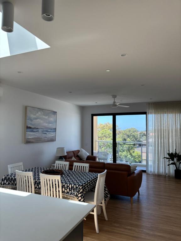 a living room with a couch and a table and chairs at The Arthur Apartments in Coffs Harbour