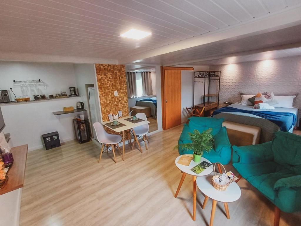 a living room with a bed and a couch and tables at Pousada Bella Vista - no coração do Vale dos Vinhedos in Bento Gonçalves