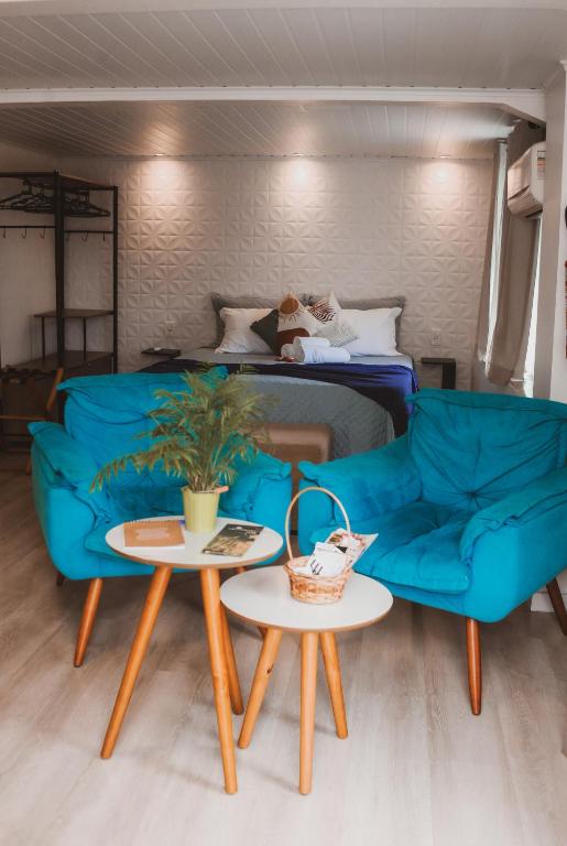 a living room with a blue couch and two tables at Pousada Bella Vista - Vale dos Vinhedos in Bento Gonçalves