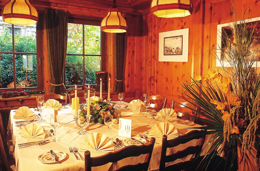 ein Esszimmer mit einem langen Tisch mit Blumen und Kerzen in der Unterkunft Land-gut-Hotel Landgasthof Hotel Ochsen in Schömberg