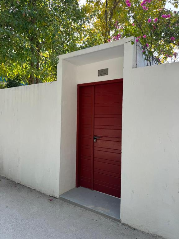 a red garage door in a white wall at Sea View in Meedhoo
