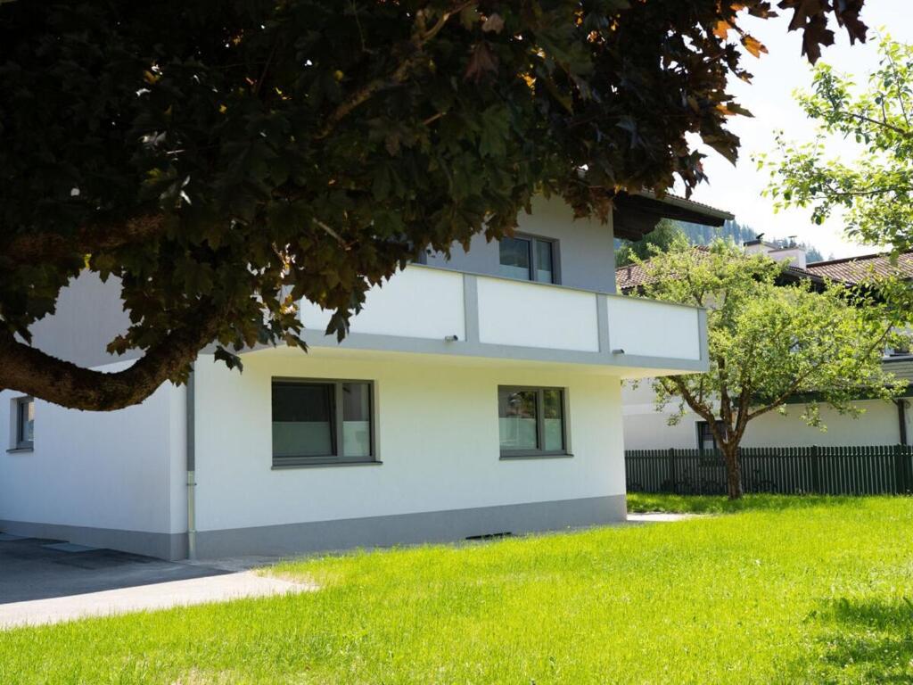 a white house with a tree in front of it at Apartment Bär Comfortable holiday residence in Eben im Pongau