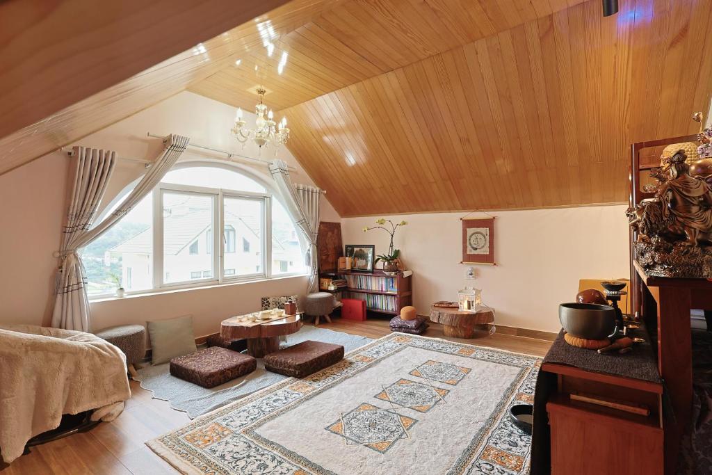 a living room with a large window and a large rug at The Hill An Sơn DIC in Xuan An