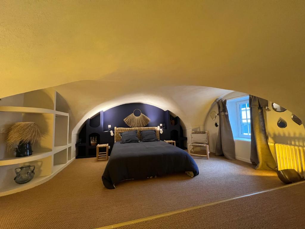 - une chambre avec un grand lit dans une pièce voûtée dans l'établissement 60 m2 Dar Blue Centre Historique Clermont-Ferrand Cathédrale, à Clermont-Ferrand