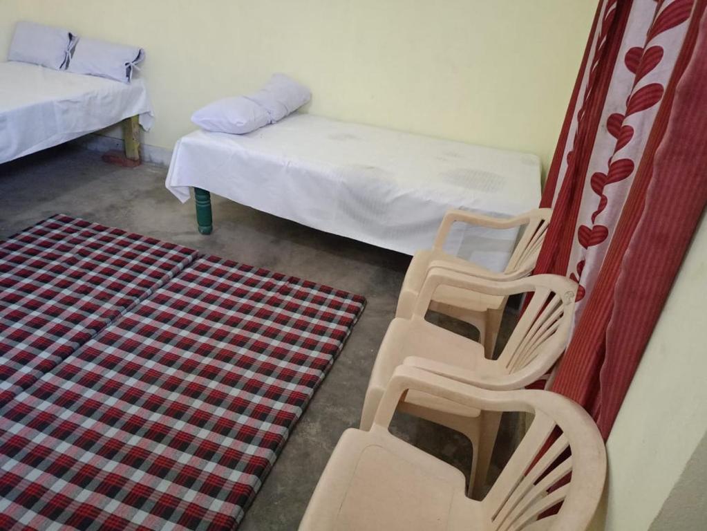 a room with two chairs and a bed and a rug at Samriddhi Home stay in Prayagraj
