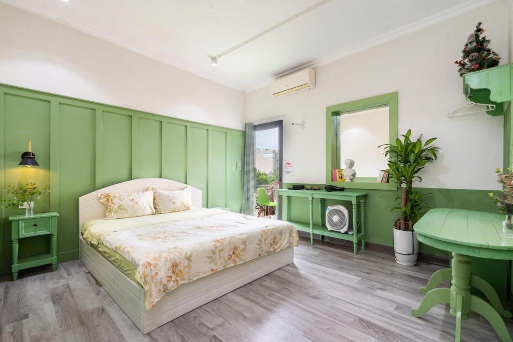 una camera da letto verde e bianca con un letto e un tavolo di RARE artistic European style 3BR 200m2 5 minute to Hoan Kiem a Hanoi