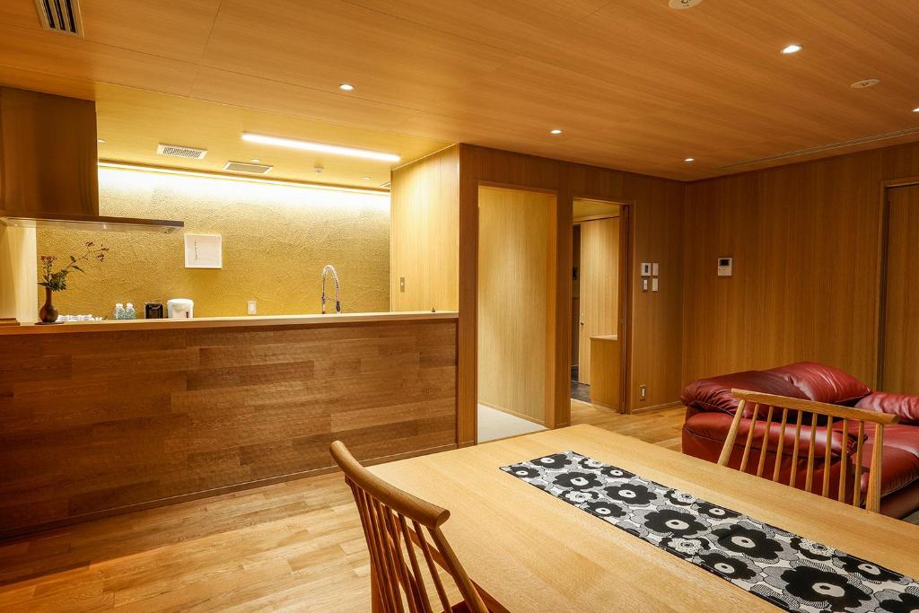 a dining room with a table and a kitchen at Yuraku Kinosaki Spa & Gardens in Toyooka