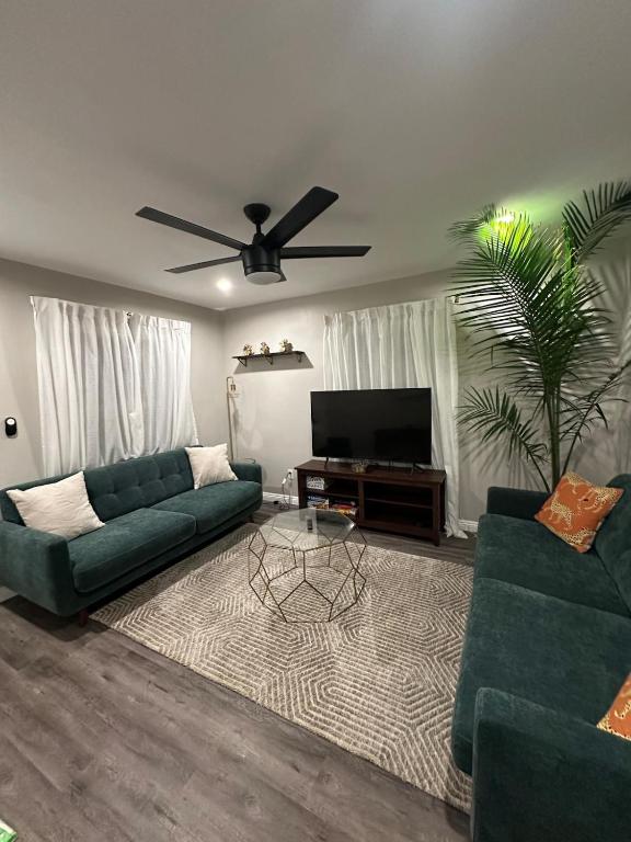 a living room with two green couches and a television at Bungalow in San Diego