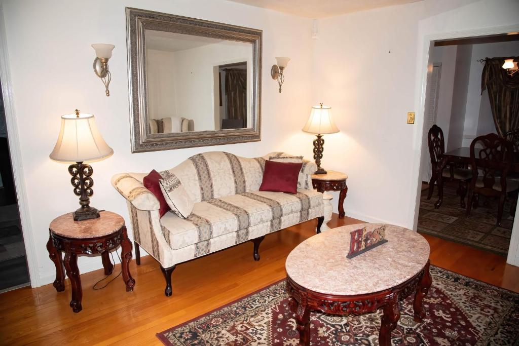 a living room with a couch and two tables and a mirror at COBE Enterprise in Danville