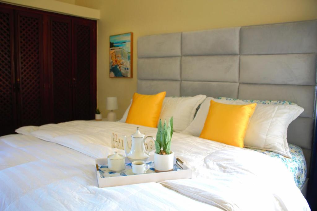 Una cama blanca con una bandeja con cactus. en Paramount Views, en San Felipe de Puerto Plata