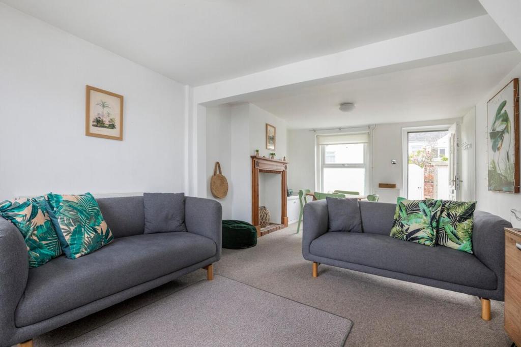 a living room with two couches and two windows at Seaside home tucked one row back from Deal beach in Deal