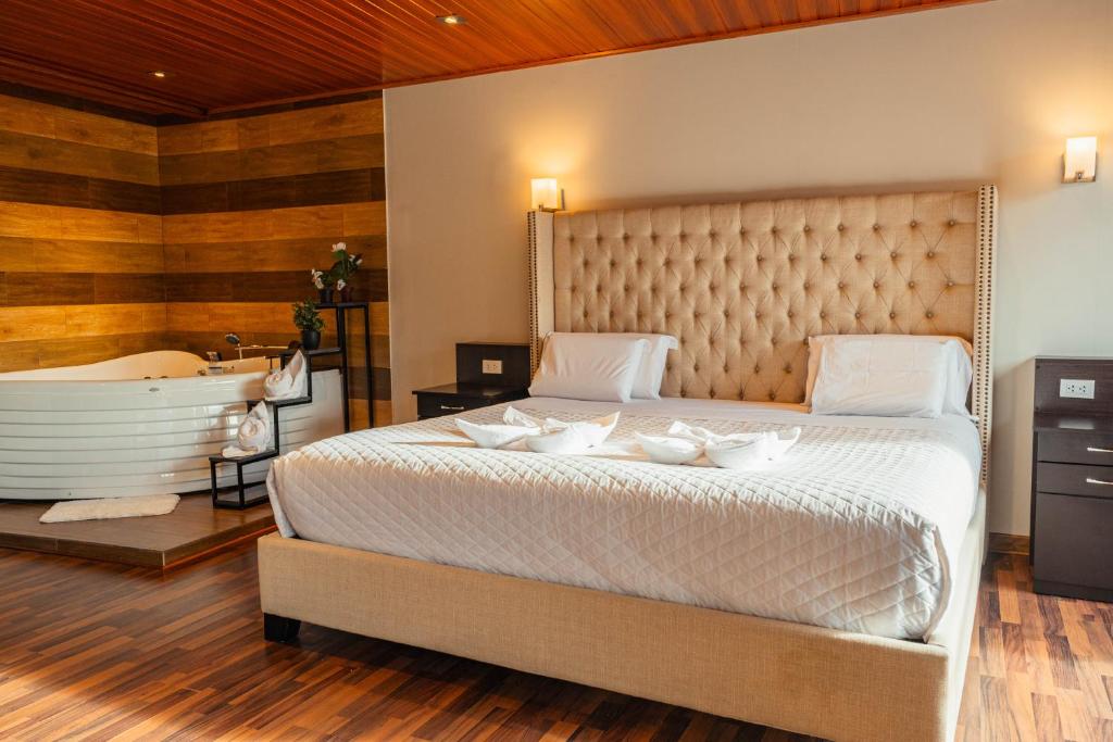 a bedroom with a large bed and a bath tub at Hotel California Urubamba in Urubamba