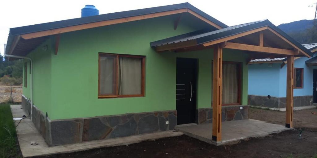 a small green house with a brown roof at Cabañas Kaldak in Lago Puelo