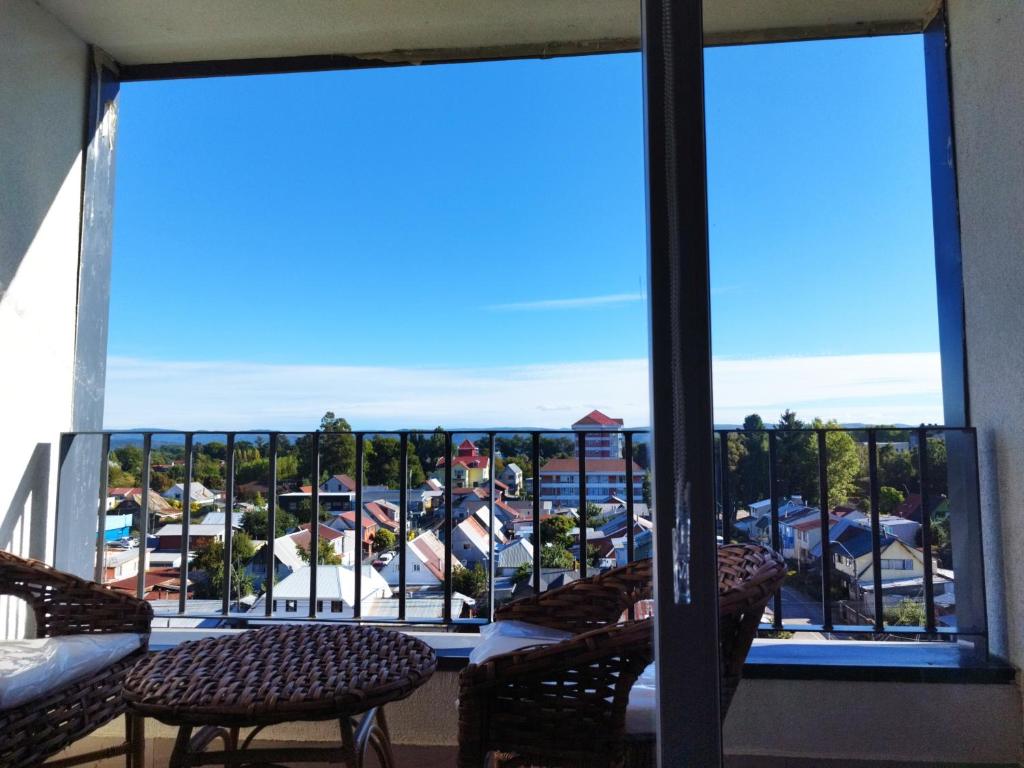a balcony with chairs and a view of a parking lot at Departamento encanto del sur isla teja in Valdivia