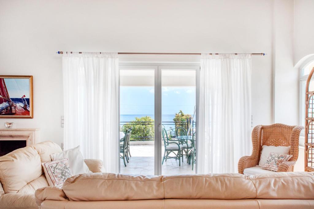 Una sala de estar con un sofá y vista al mar. en The Beach House, en Hersonissos