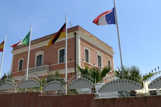 un edificio con banderas delante en Villa Corallo Dell'Etna, en Acireale
