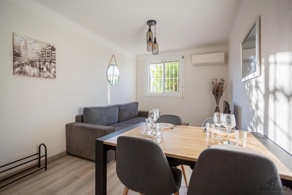 une salle à manger avec une table, des chaises et un canapé dans l'établissement Le coin des agrumes Jardin Proche Centre Ville, à Perpignan