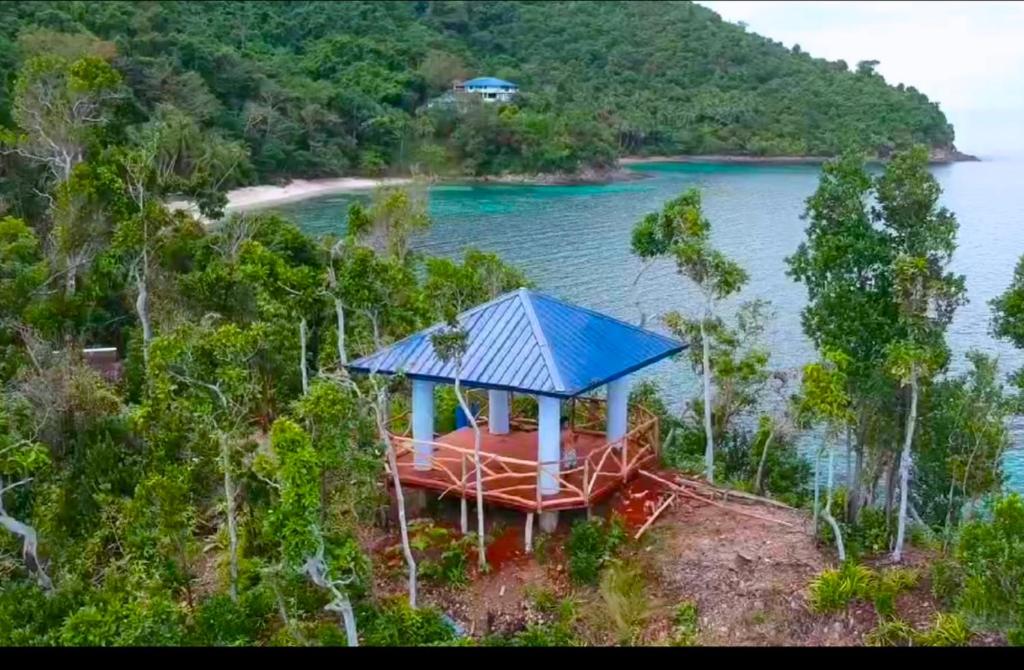 a house with a blue roof on top of a body of water at ISLA tress Bonita Wellness Escape Island in San Vicente
