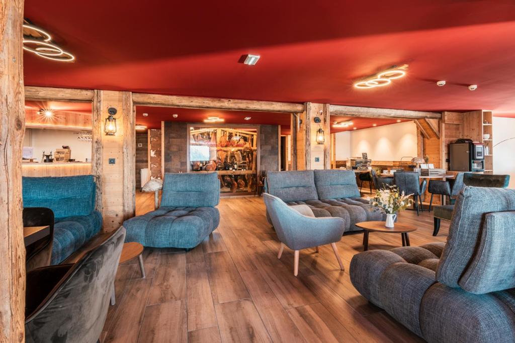 a living room with blue couches and a bar at L'Escale (accès en télécabine) in Châtel