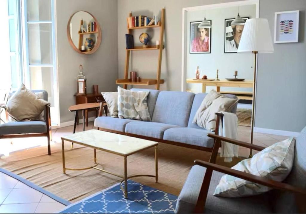 un salon avec un canapé bleu et une table dans l'établissement Lamour Pezenas hideaway, à Pézenas