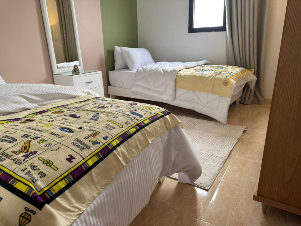 une chambre avec deux lits et un miroir dans l'établissement Golden View Pyramids Hotel, au Caire