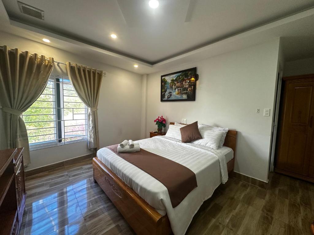 a bedroom with a large bed and a window at Holiday Hotel in Phu Quoc
