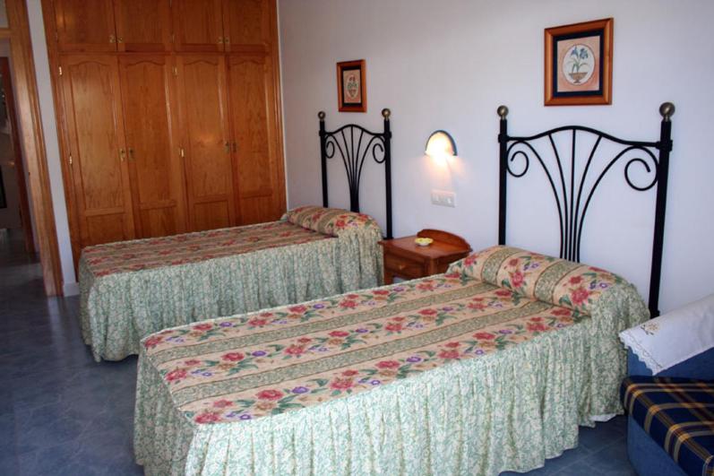 a hotel room with two beds and a door at Hostal Brisamar in San José