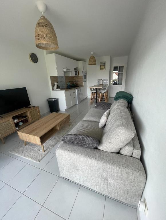 un salon avec un canapé et une table dans l'établissement Appartement à 400m de la plage - 6 couchages, à Neufchâtel-Hardelot