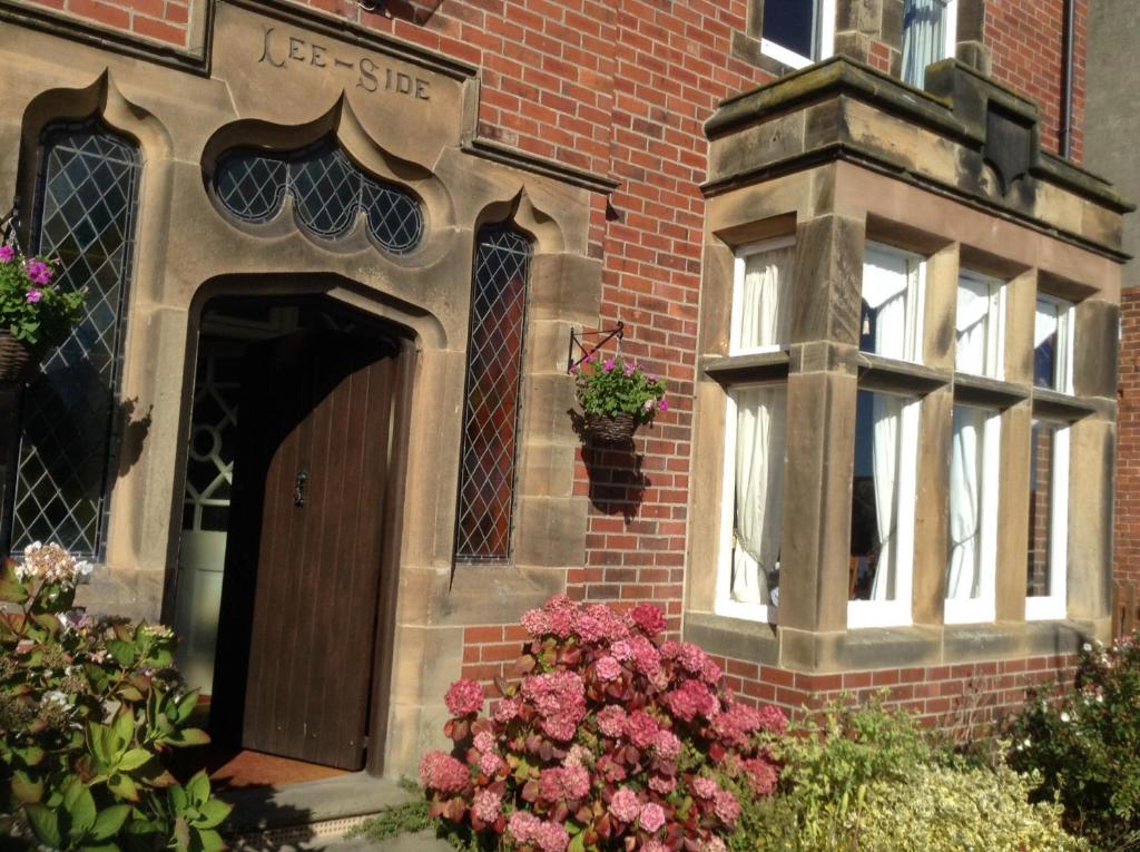 een gebouw met een deur en bloemen ervoor bij Lee-Side B&B in Robin Hood's Bay