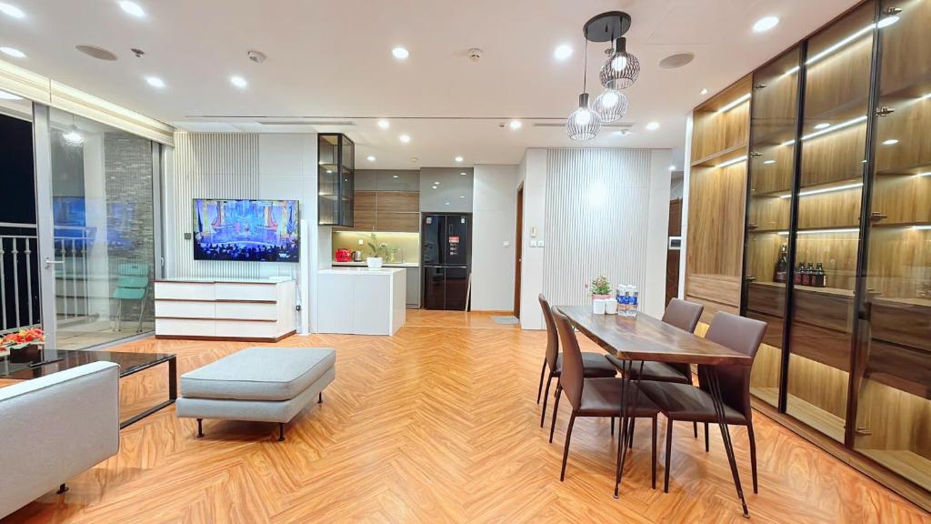 a living room with a dining table and a television at LEÉ BOISE Hà Nội - Luxury Apartment in Vinhomes Times City in Hanoi