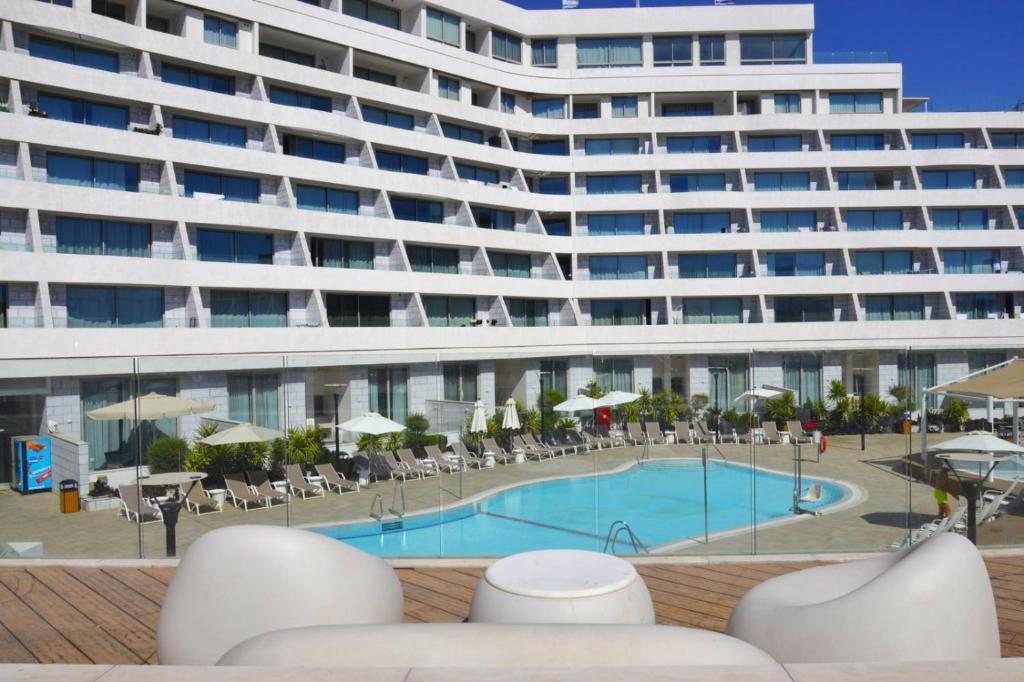 a large building with a swimming pool in front of a building at סי סייד אילת סוויטה משפחתית 2 חדרים עם מרפסת ונוף לים in Eilat