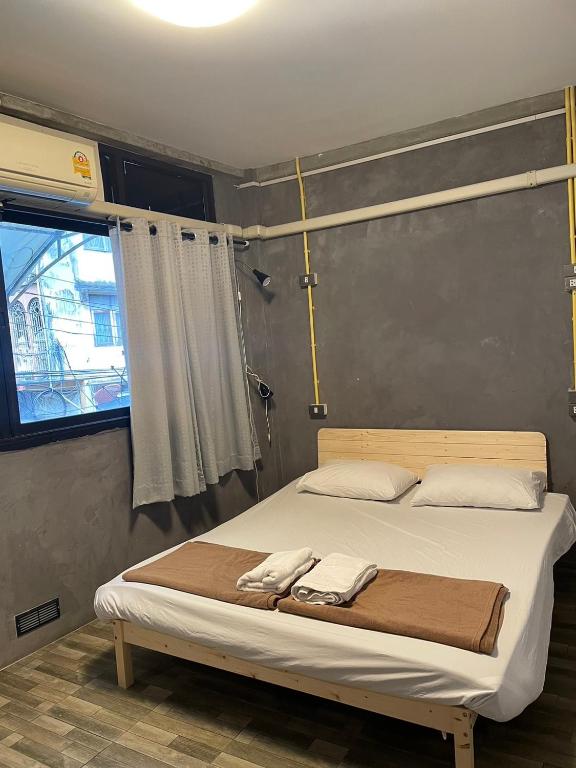 a bed with two towels on it in a bedroom at Brio Cafe and Hostel in Godown