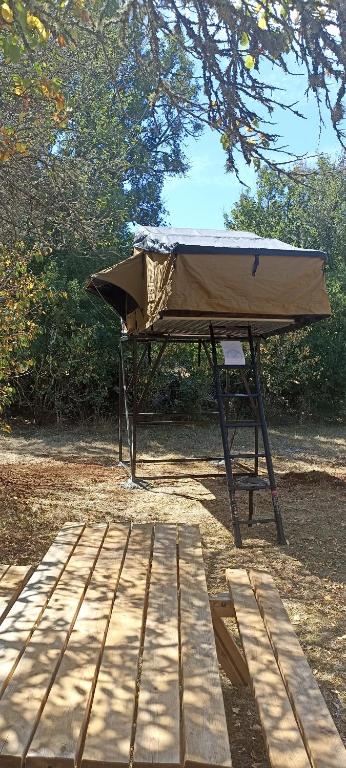 a picnic table with a cover on top of it at Tente Perchée Kenya MAS DE BOUZOU in Grèzes