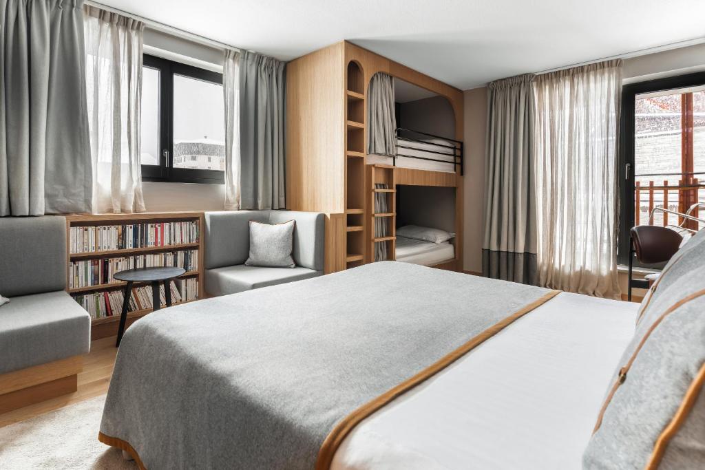 a bedroom with a bed and a chair and a book shelf at Heliopic Hotel & Spa in Chamonix