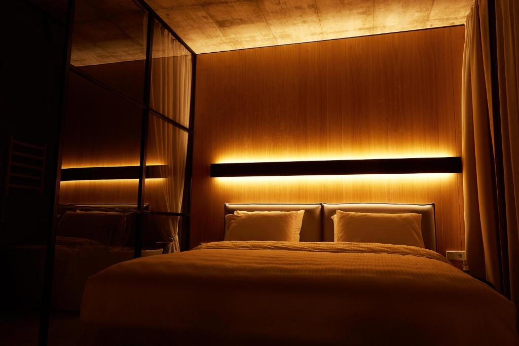 a bedroom with a bed with a light above it at Air Hotel in Karmėlava