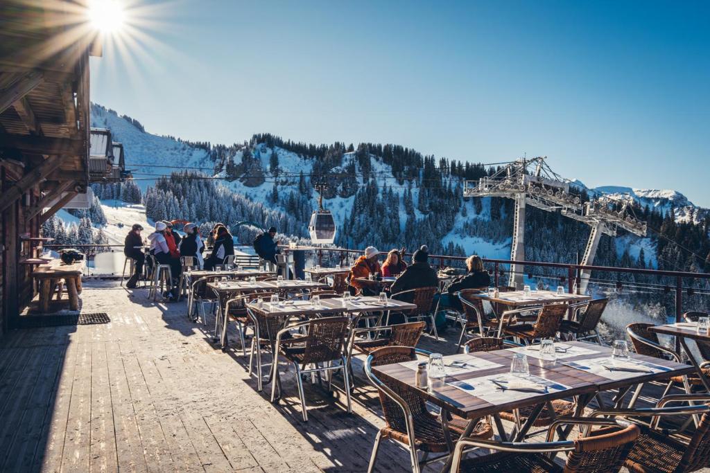 a group of people sitting at tables on a ski slope at L'Escale (accès en télécabine) in Châtel